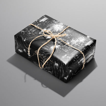 A single rectangular gift wrapped in Skyline Celebration—city lights and fireworks on black—tied with natural twine on a cool gray background.