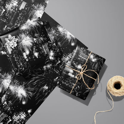 Two gifts in Skyline Celebration—one with a silver bow and one tied with twine—rest on two unused sheets beside a spool of twine on a cool gray background.
