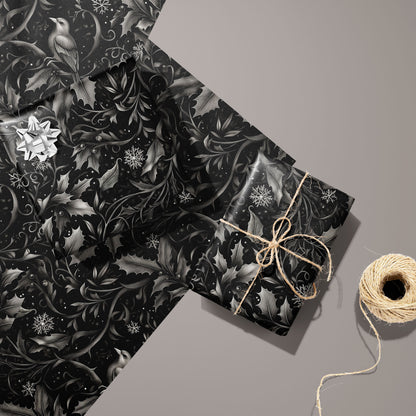 Two gifts in Winter Song—one with a silver bow and one tied with twine—rest on two unused sheets with birds, holly, and snowflakes on a black field beside twine on taupe.