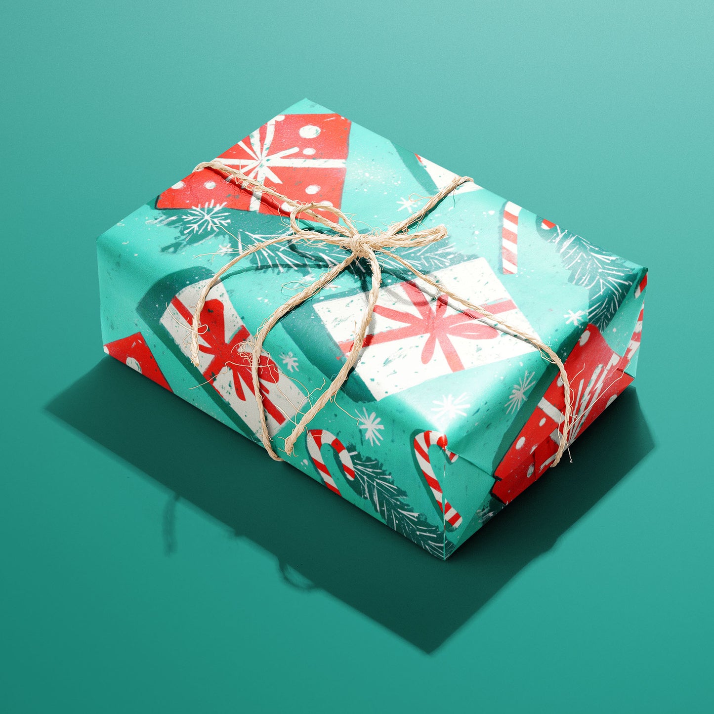 A single gift wrapped in Peppermint Pop and tied with natural twine displays candy canes, red bows, pine sprigs, and snowflakes on a teal-green background.
