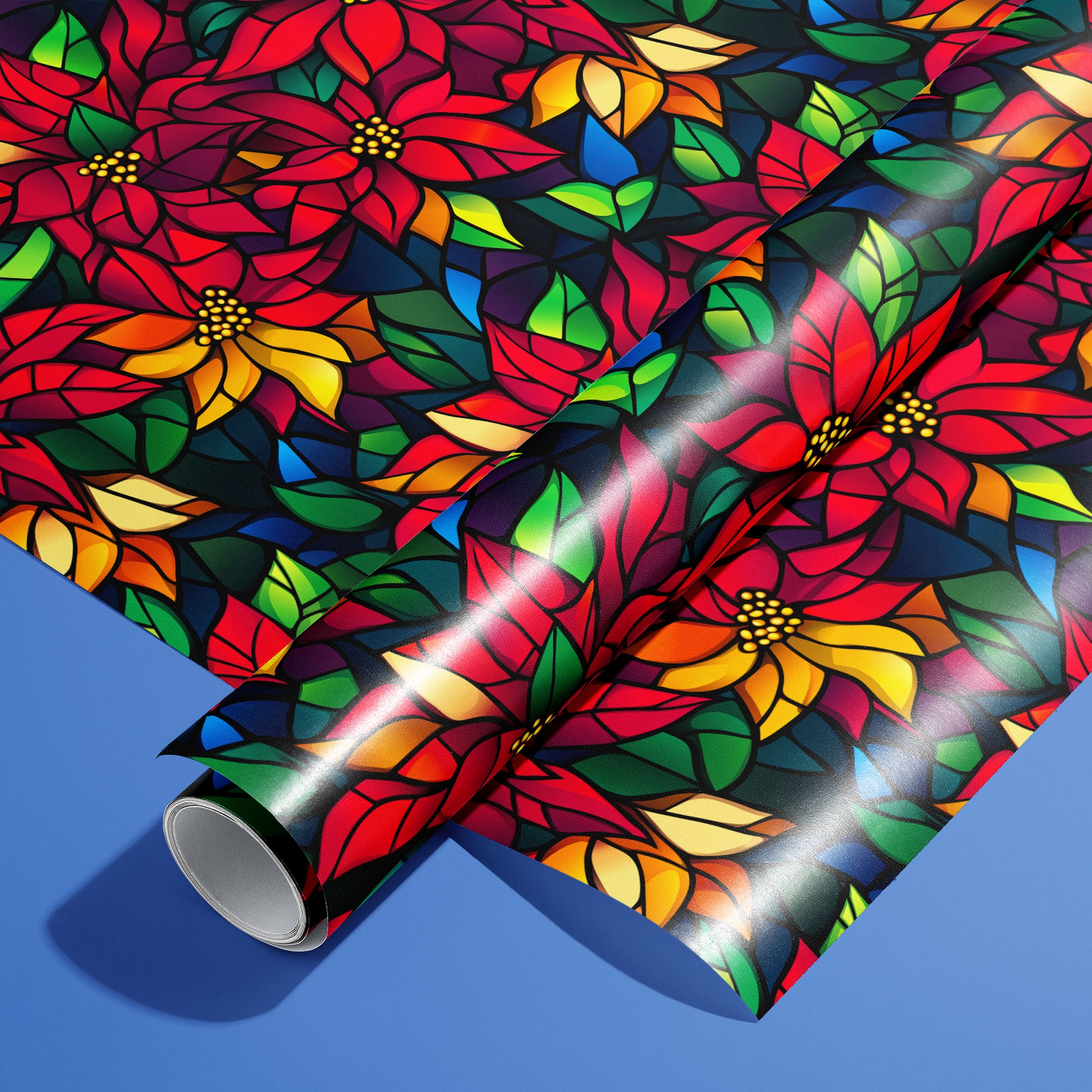 A roll of Poinsettia Prism on an unrolled sheet, showing stained-glass poinsettias with jewel-tone leaves on a black ground, set on a bright cobalt-blue surface.