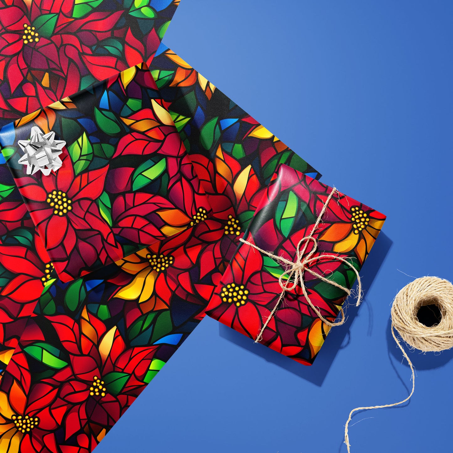Two gifts in Poinsettia Prism—one with a silver bow, one tied with twine—rest on two matching sheets next to a twine spool, with stained-glass poinsettias on black over cobalt blue.