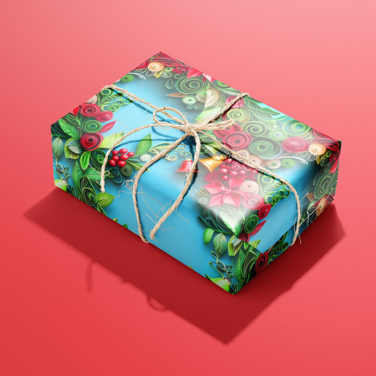 A single gift wrapped in Yuletide Twirls and tied with natural twine shows quilled wreaths with poinsettias, holly, and bells on a sky-blue ground against a red background.