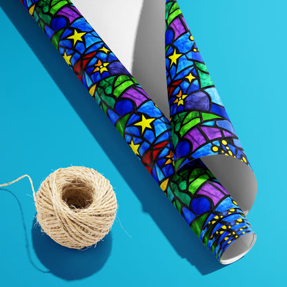 A partially unfurled roll of Starlit Holiday, white underside visible beside a spool of natural twine, displays stained-glass stars and trees on a bright cyan surface.