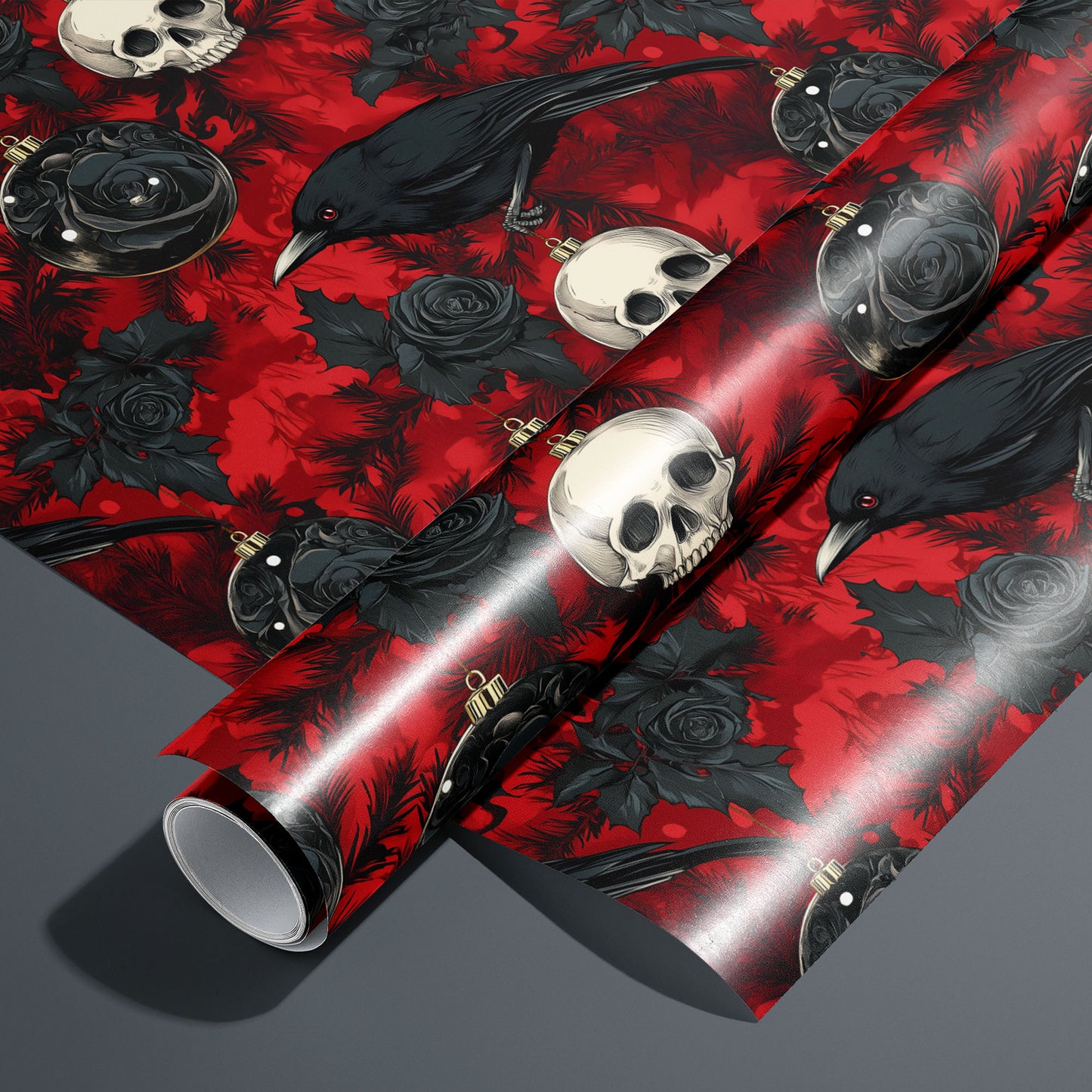 A roll of Merry Macabre rests on an unrolled sheet, showing ravens, ivory skulls, black roses, and dark glass ornaments amid inky pine boughs on a crimson ground, styled on a charcoal gray surface.