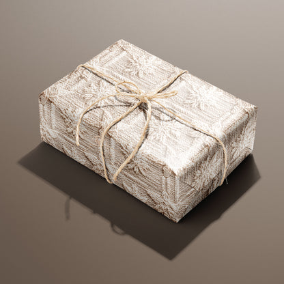 A single rectangular gift wrapped in Winter Weave and tied with natural twine highlights a cozy knit snowflake design in cream and beige on a warm brown backdrop.