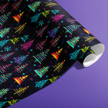 A partially unfurled roll of Glitchmas Trees gift wrap displays stacked, glitchy triangular trees with digital noise on a dark ground against an electric purple background.