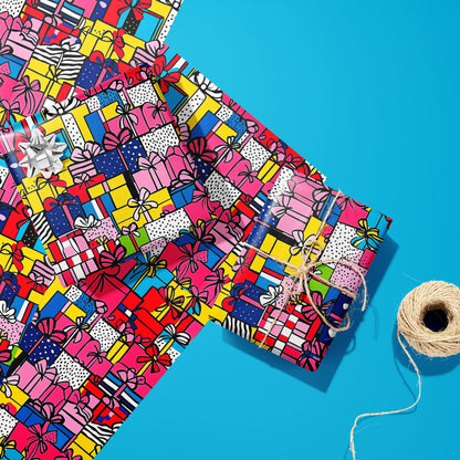 Two gifts in Pop Art Presents—one with a silver bow and one tied with twine—rest on two unused sheets beside a twine spool on a bright cyan surface, showing pop-art presents.