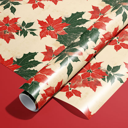ALT Tag
A roll of Woodblock Poinsettias wrapping paper resting on a matching unrolled sheet, featuring vintage red poinsettias and green holly on cream paper over a red background.