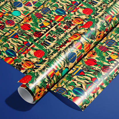 A roll of Retro Ornament Celebration wrapping paper resting on a matching unrolled sheet, covered in colorful midcentury ornaments and evergreen sprigs on a cream background over deep blue.