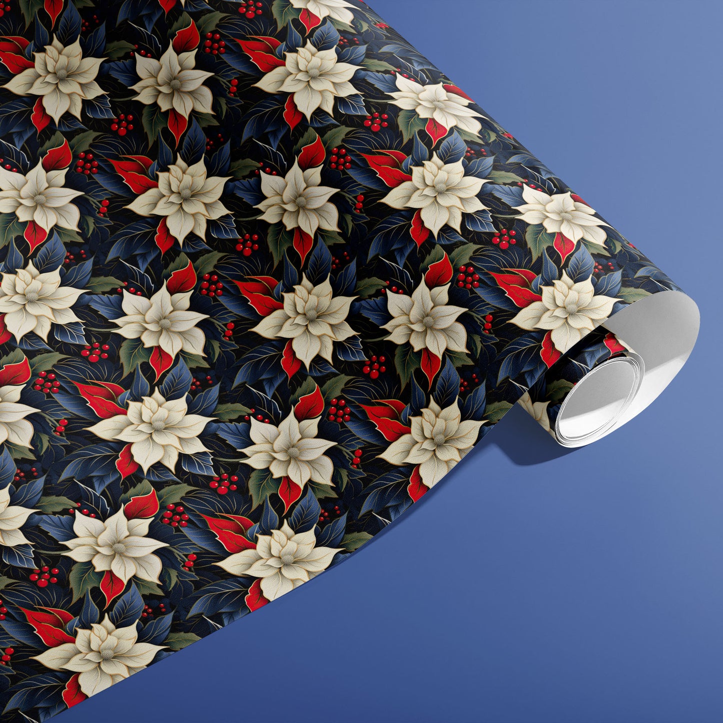 A partially unfurled roll of Elegant Poinsettias gift wrap showing repeating cream poinsettia blooms, red leaves and holly berries on deep navy paper against a soft blue surface.