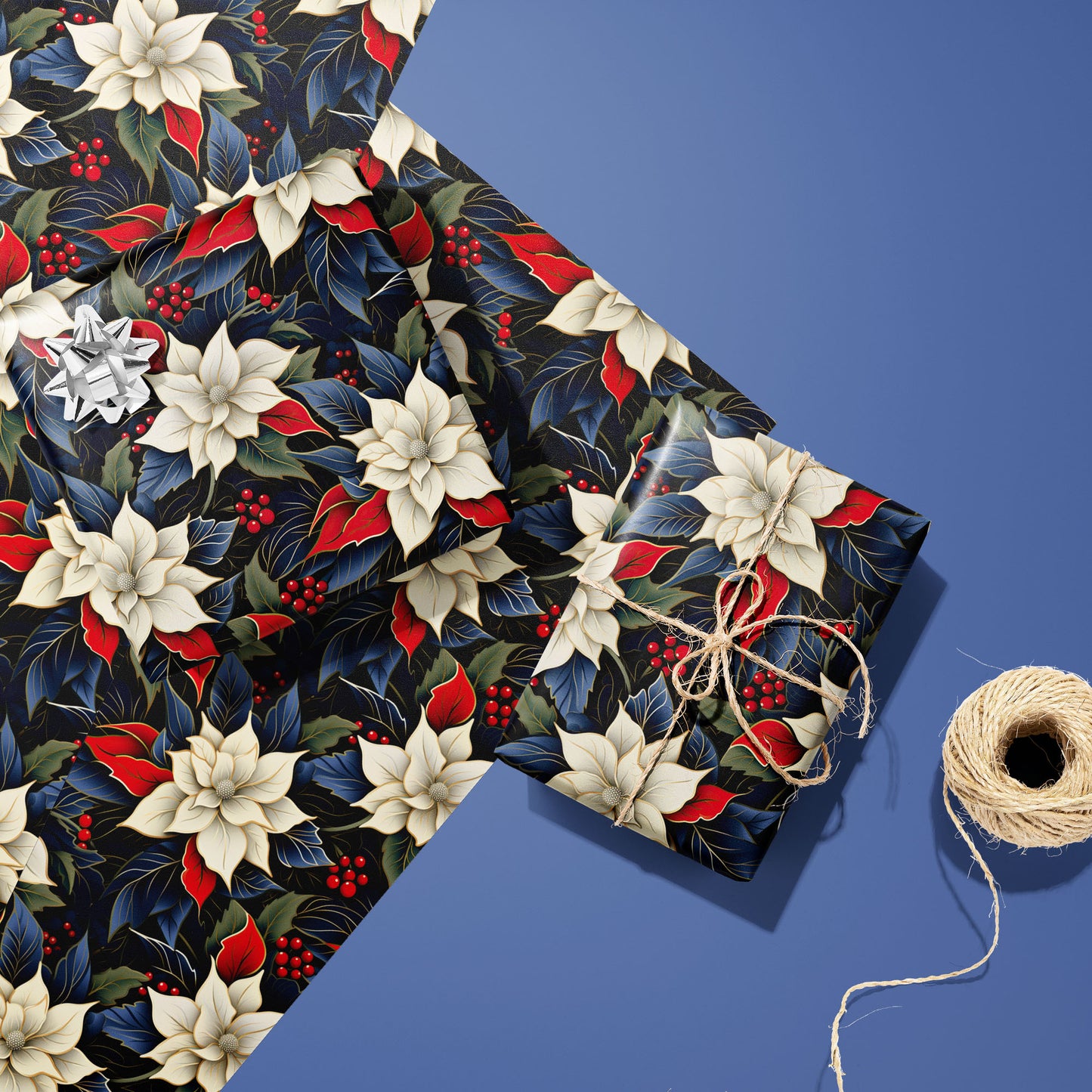 Two gifts wrapped in Elegant Poinsettias floral paper, one topped with a silver bow and one tied with twine, resting on extra sheets beside twine on a blue surface.