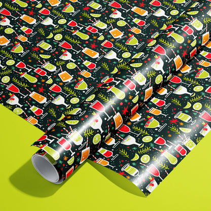 A roll of Christmas Cocktails wrapping paper resting on a matching unrolled sheet, patterned with colorful holiday drinks and citrus on dark paper over a bright lime green background.