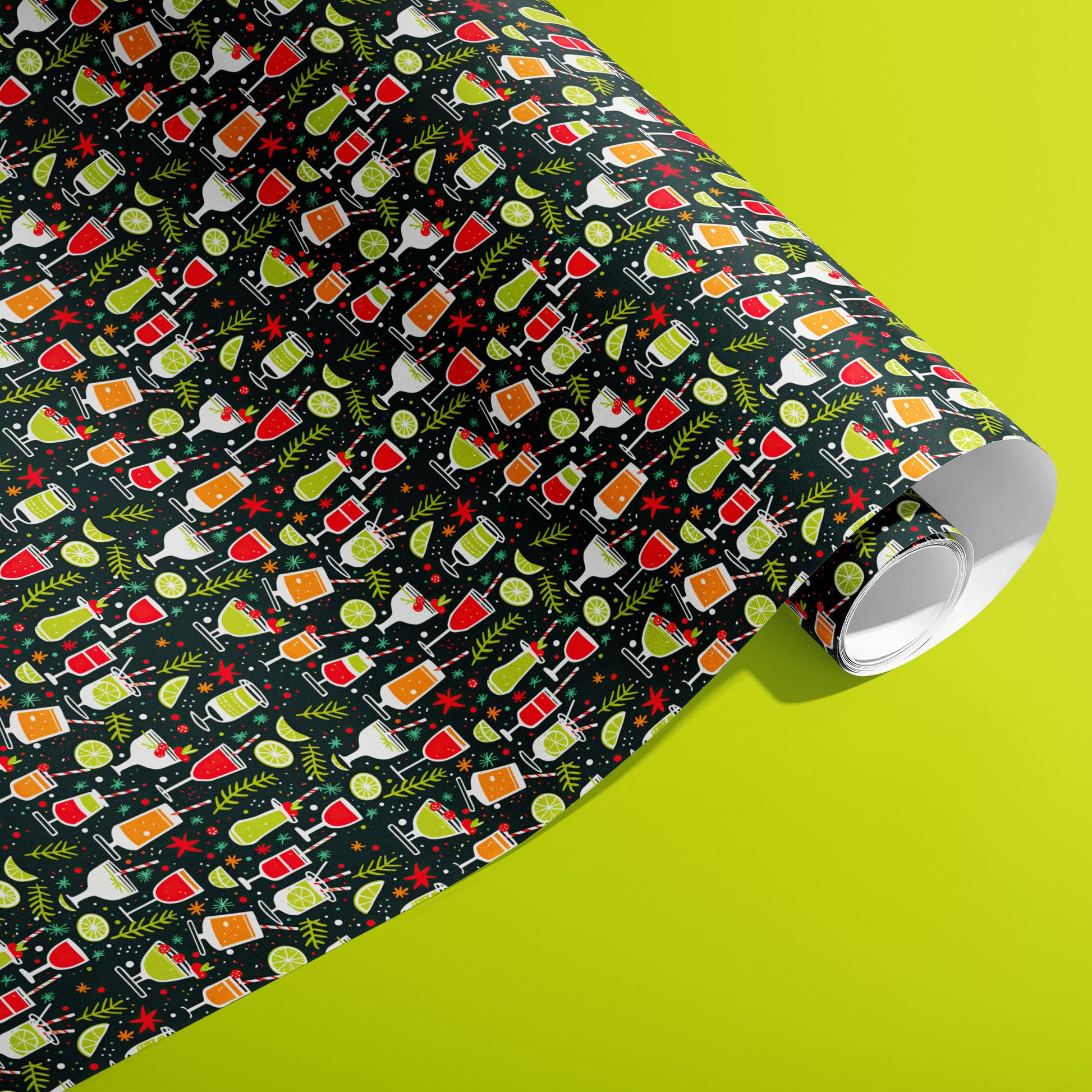 A partially unfurled roll of Christmas Cocktails gift wrap showing rows of whimsical cocktail glasses, lime slices and sprigs on deep charcoal paper against a vivid lime green surface.