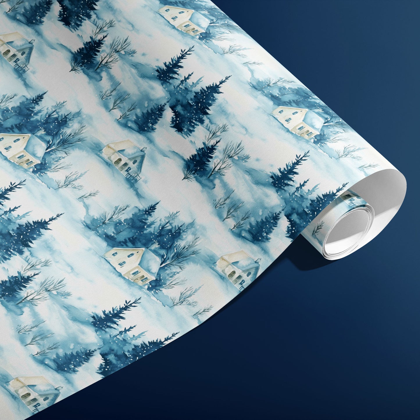 A partially unfurled roll of Cozy Cottage gift wrap showing repeating snowy cottages and evergreen forests in watercolor blues on a deep navy surface.