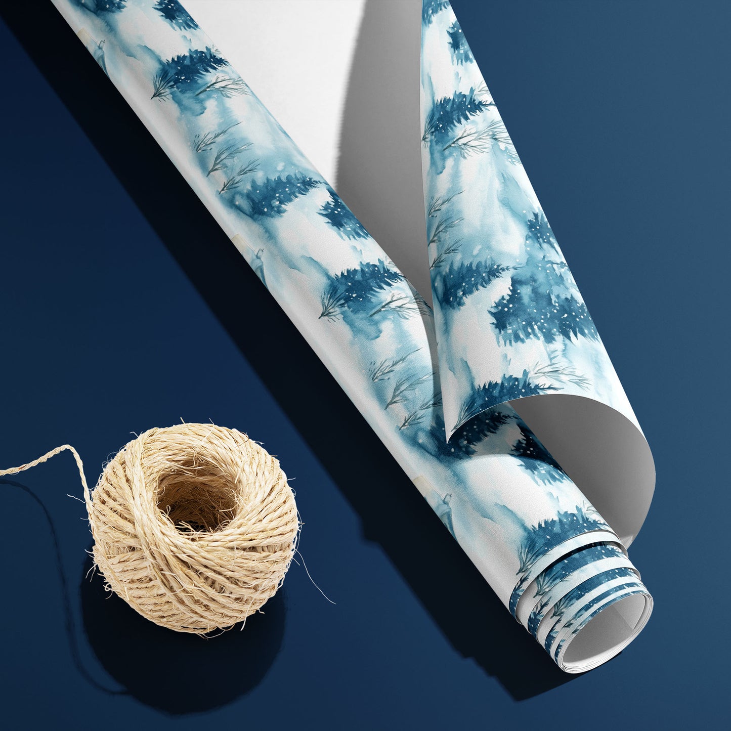 A curled roll of Cozy Cottage wrapping paper revealing its white underside beside a spool of natural twine on a rich navy blue background.